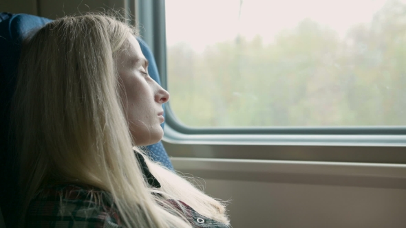 Young Caucasian Woman Look Thru The Window While Traveling By Train