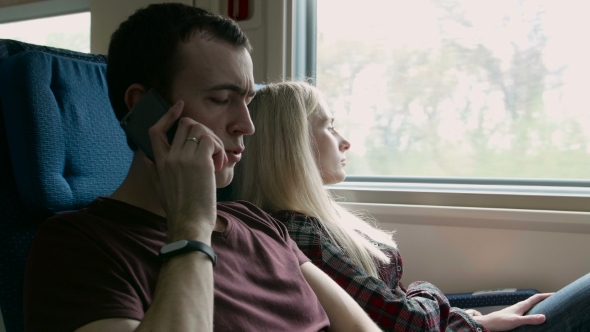 Young Angry Man Talk To Somebody On a Phone On a Moving Train
