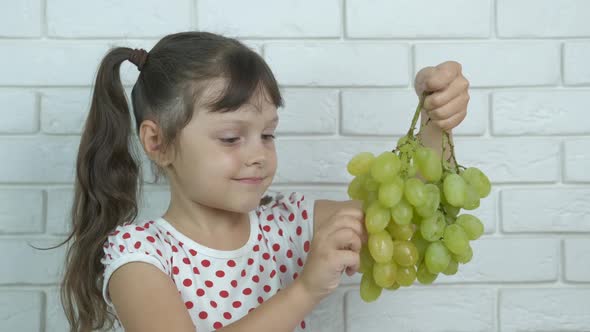 A child with grapes. 