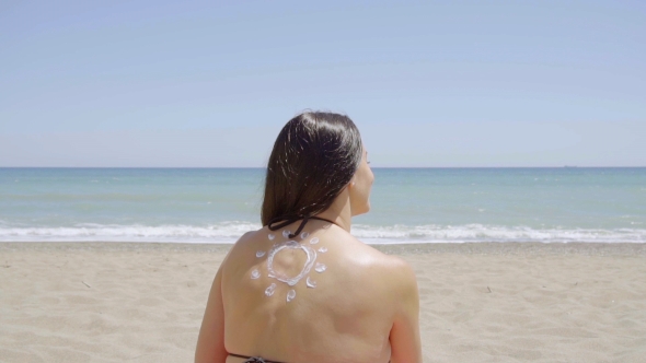 Young Woman With a Sunscreen Sun On Her Back