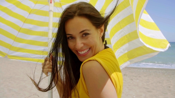 Flirtatious Young Woman Holding a Beach Umbrella