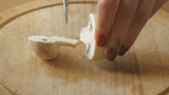 Girl's Hands With Red Nails Cut Champignon Into Slices