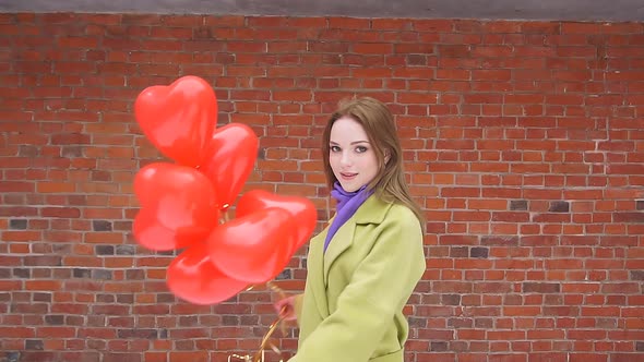 Slow-motion Picture of a Romantic Young Woman Enjoying Balloons. A Woman Is Spinning with Balloons