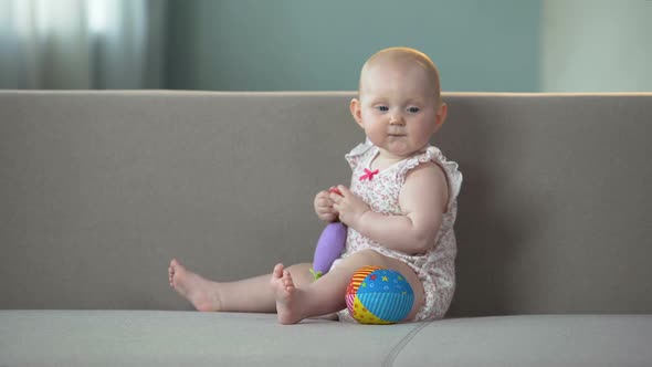 Baby Smiling and Playing With Toys on Sofa, Infant Enjoying Comfort in Diapers