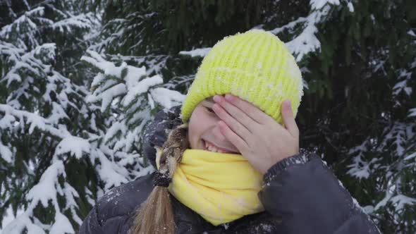 Portrait of a Happy Teenage Girl in a Snowy Park