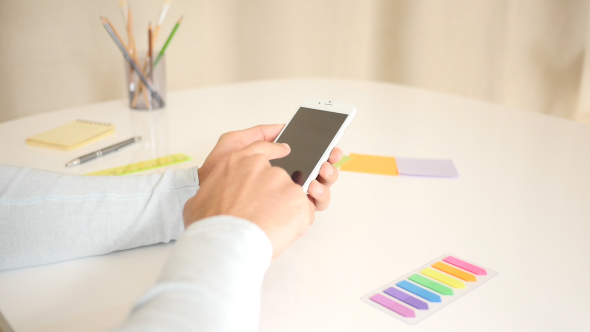 Freelancer Typing Using Smartphone On Desk