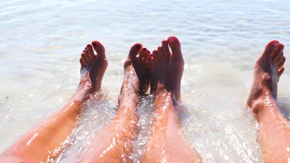Feet of a couple relaxing on the beach