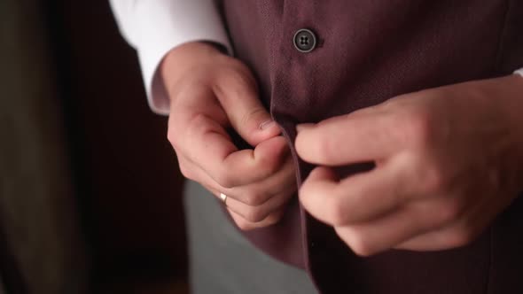 a Man Buttons the Buttons on the Suit