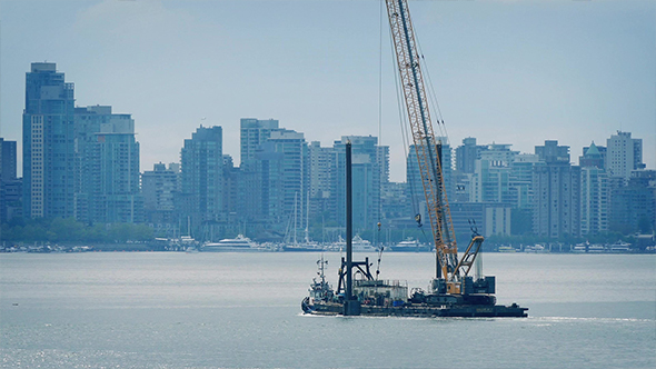 Barge Transporting Crane Near City Waterfront alt