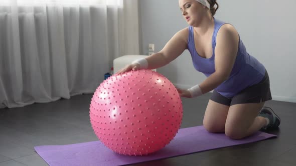Funny Lazy Girl Lying on Big Fitness Ball, Unable to Do Weight Loss Exercises