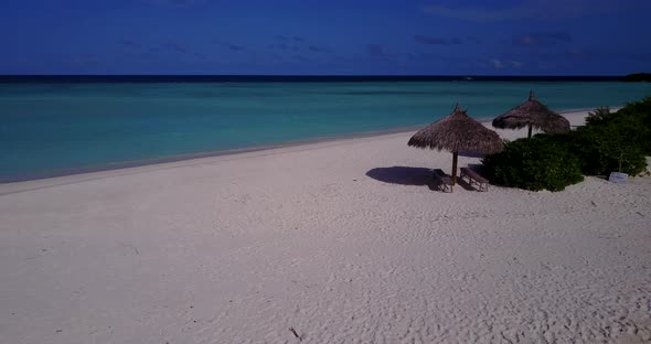 Natural fly over island view of a sunshine white sandy paradise beach and aqua blue ocean background