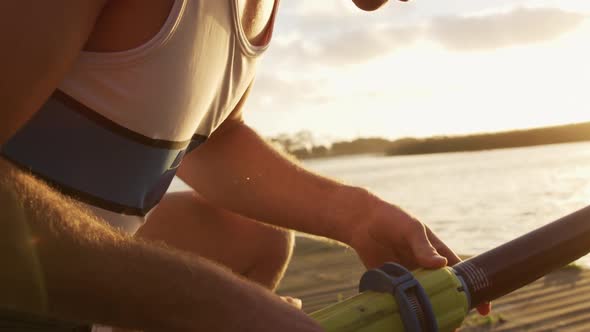 Caucasian rower looking at the structure of the oar