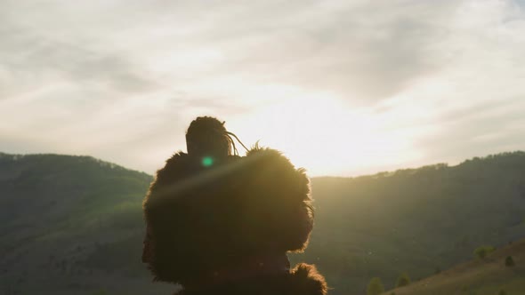 Performer Raises Up and Taps Shaman Drum at Sunrise