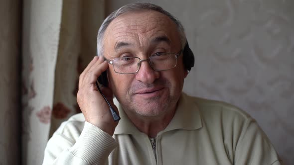 Smiling Senior Man Wear Earphones Wave to Camera Having Video Call on Laptop Happy Elderly Male i