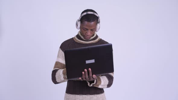 Young Happy African Man Using Laptop Ready for Winter