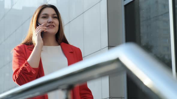 Business Woman in a Red Jacket Talking on the Phone