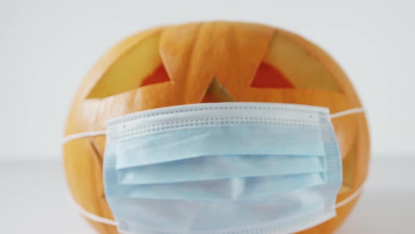 Composition of halloween orange pumpkin with face mask against white background