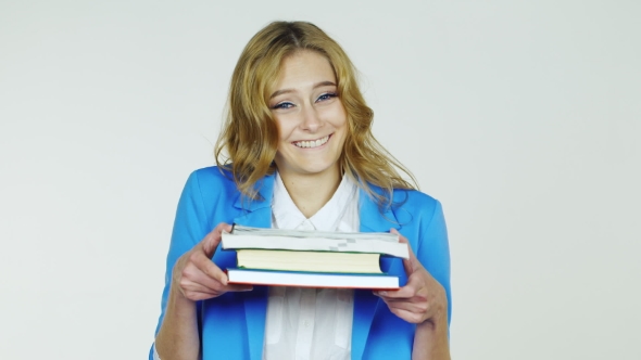 Female Student Holding a Stack Of Textbooks And Exercise Books, Smiling