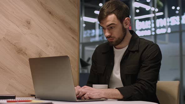 Young Focused Handsome Male Businessman Working on a Laptop