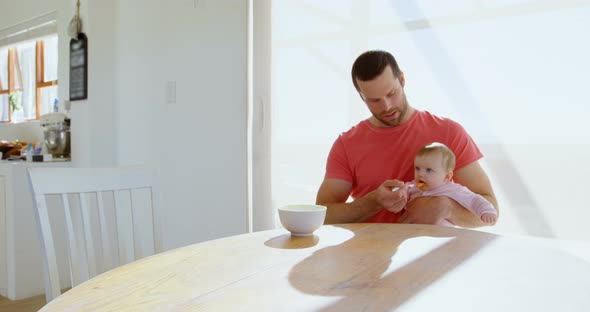 Father feeding his baby boy with spoon 