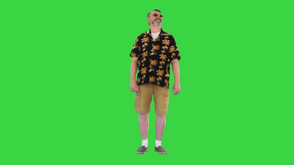 Senior Man Tourist in Sunglasses Standing and Smiling on a Green Screen Chroma Key