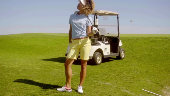 Young Woman Golfer Standing Above a Sand Bunker