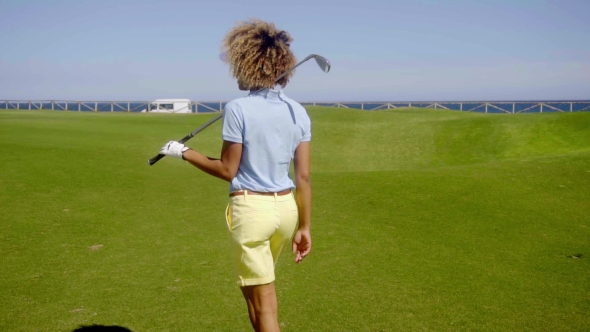 Female Golfer Walking Down a Fairway