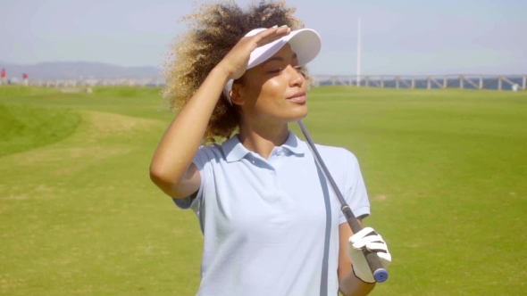 Confident Woman Enjoying Sun While Playing Golf