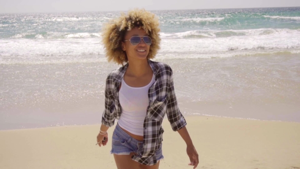 Young Woman Walking On a Windy Sandy Beach