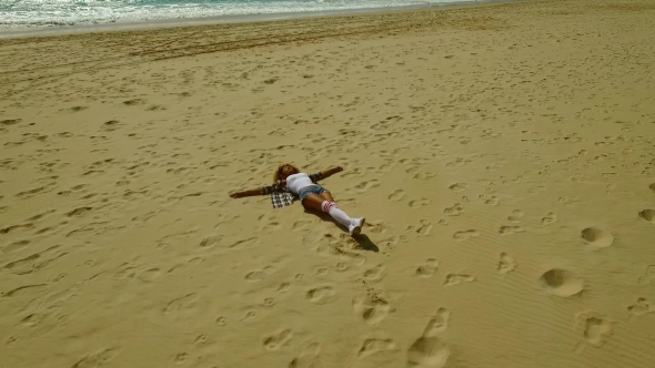 Young Woman Lying On Her Back On a Beach