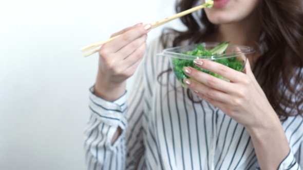 Business Woman Enjoying Fresh Salad For Lunch Break At Office Desk