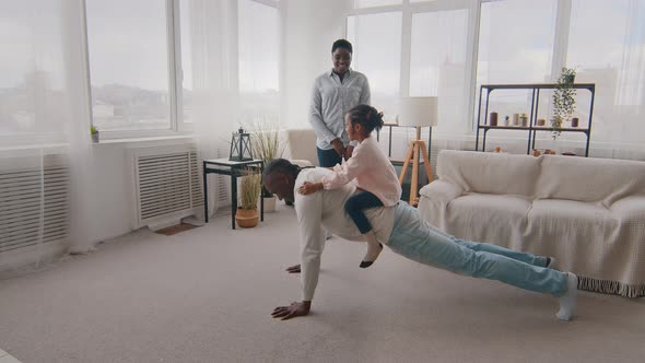 Strong African Father Black Dad Sporty Man Push Up From Floor in Living Room with Little Daughter