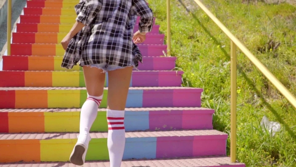 Young Woman Running Up The Stairs.