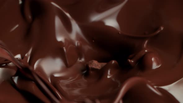 Super Slow Motion Shot of Raw Chocolate Chunks Falling Into Melted Chocolate at 1000Fps