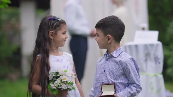 Cute Confident Middle Eastern Flower Girl and Ring Boy Posing on Marriage Ceremony Outdoors