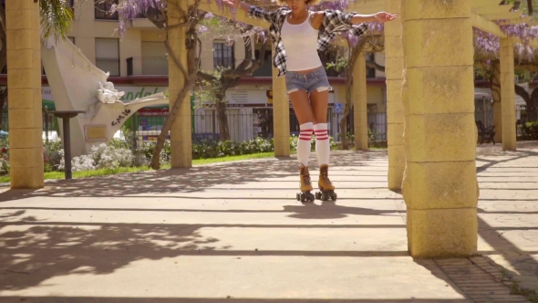 Young Woman Roller Skating On Sunny Promenade