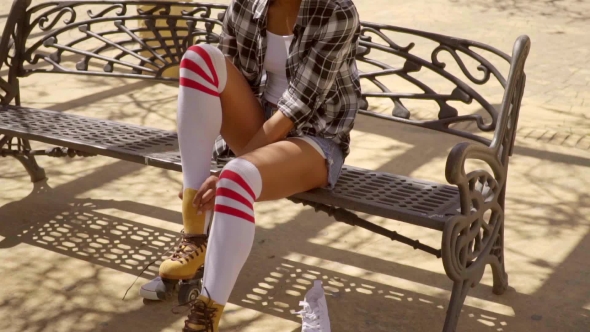 Young Woman Lacing Up Her Roller Skates