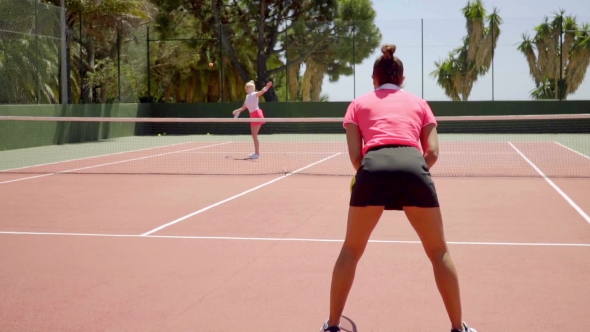 Trendy Young Tennis Players Training On a Court