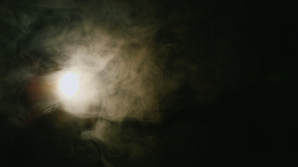 Spotlight Included In The Cloud Of Smoke On a Black Background