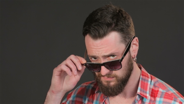 Bearded Man Lowers His Sunglasses