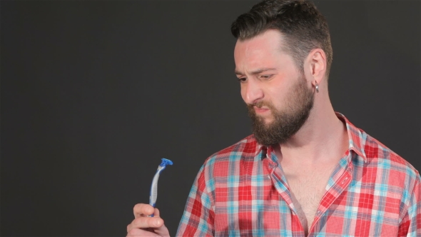 Bearded Man Looks At The Shaver
