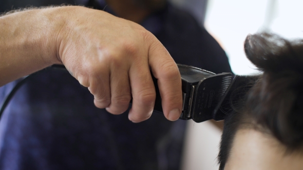 Shot Of a Handsome Bearded Barber Giving a Haircut To His Client 