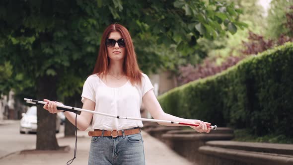 Young Blind Person with Long Cane Walking in a City