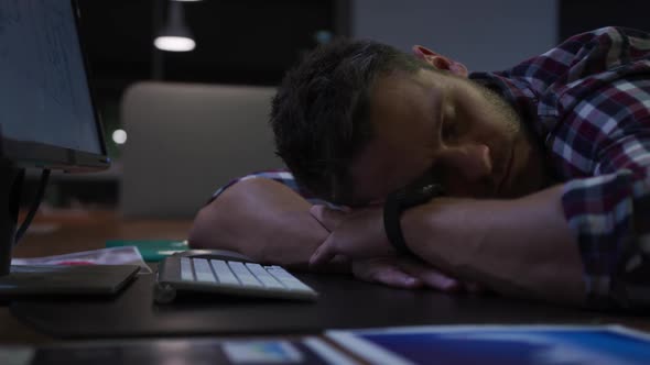 Businessman sleeping in a modern office by night