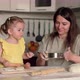 Mom and Little Daughter are Preparing Pastries at Home in the Kitchen - VideoHive Item for Sale