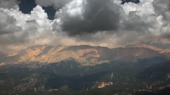 Forested and Treeless High Mountain Mass Under Dark Clouds