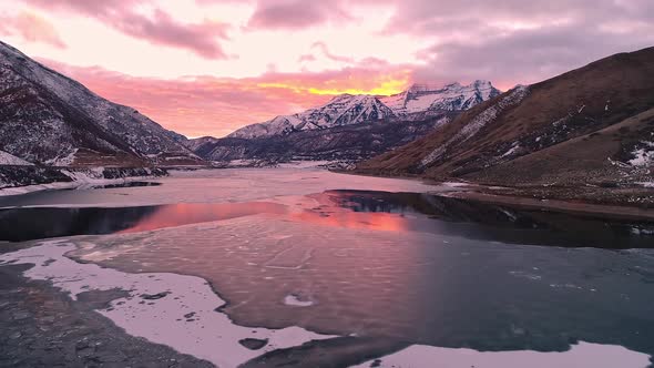 Colorful sunset glowing over lake in winter with ice sheets