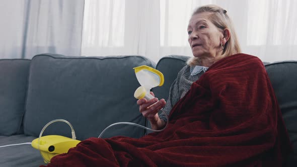 Elderly Woman Using Oxygen Mask at Her Home