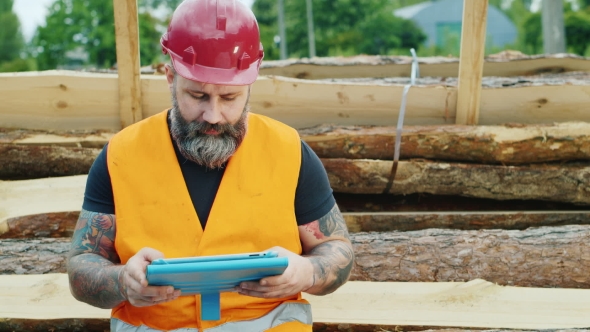 Brutal Builder Or Worker Uses a Tablet In a Break From Work alt