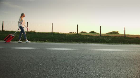 Cheerful Young Lady with Suitcase Walking on Road.